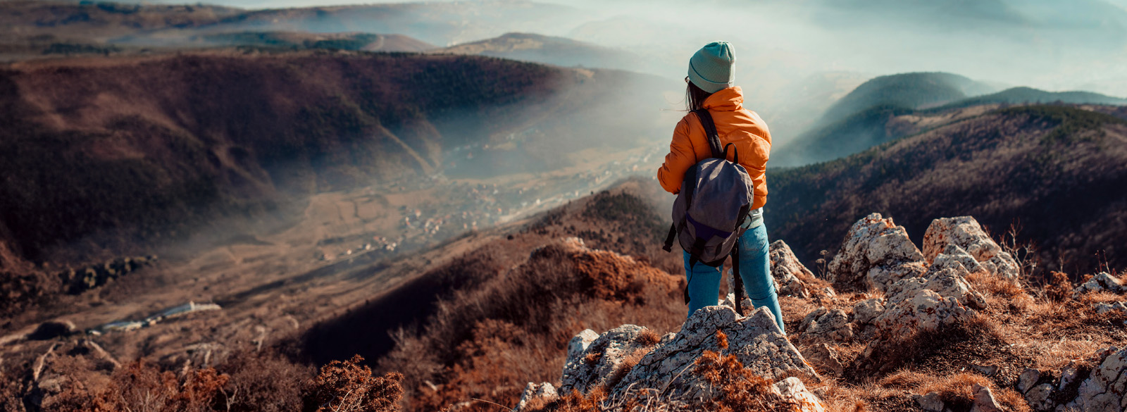 woman hiking with logoed backpack