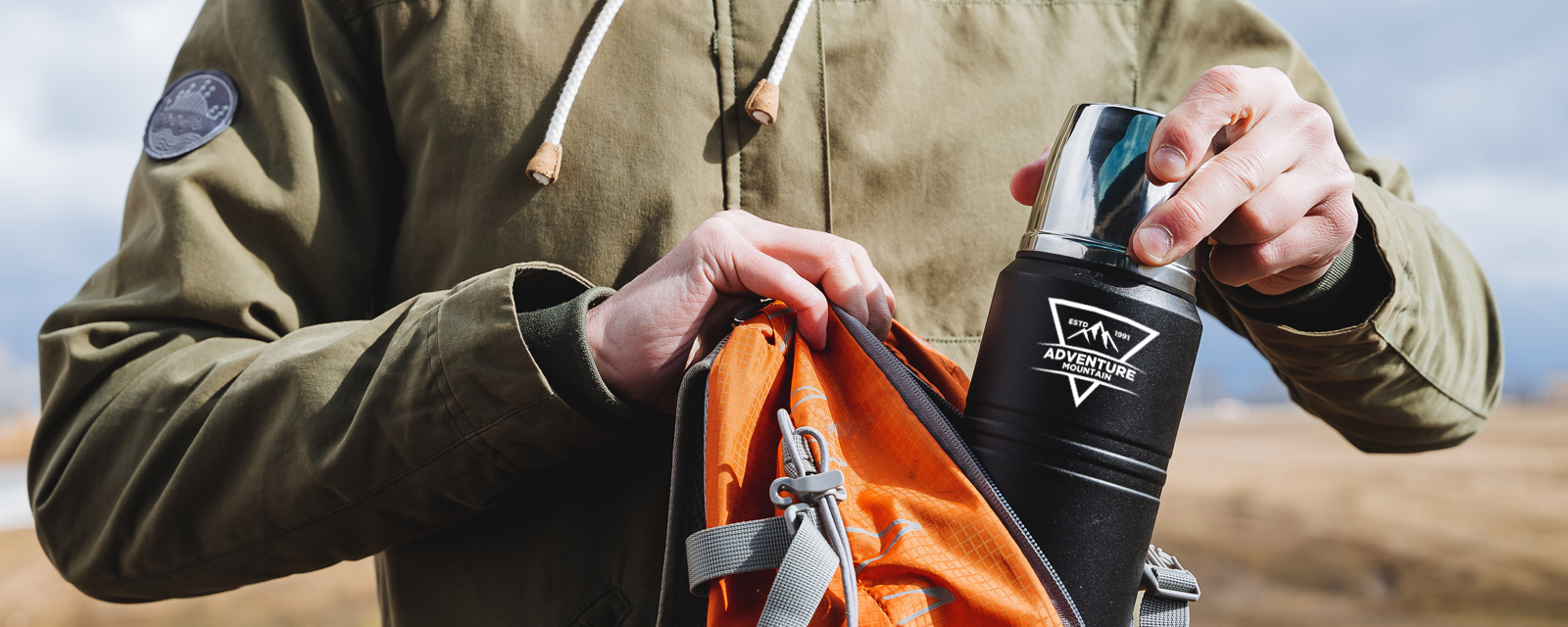 man putting thermos into backpack