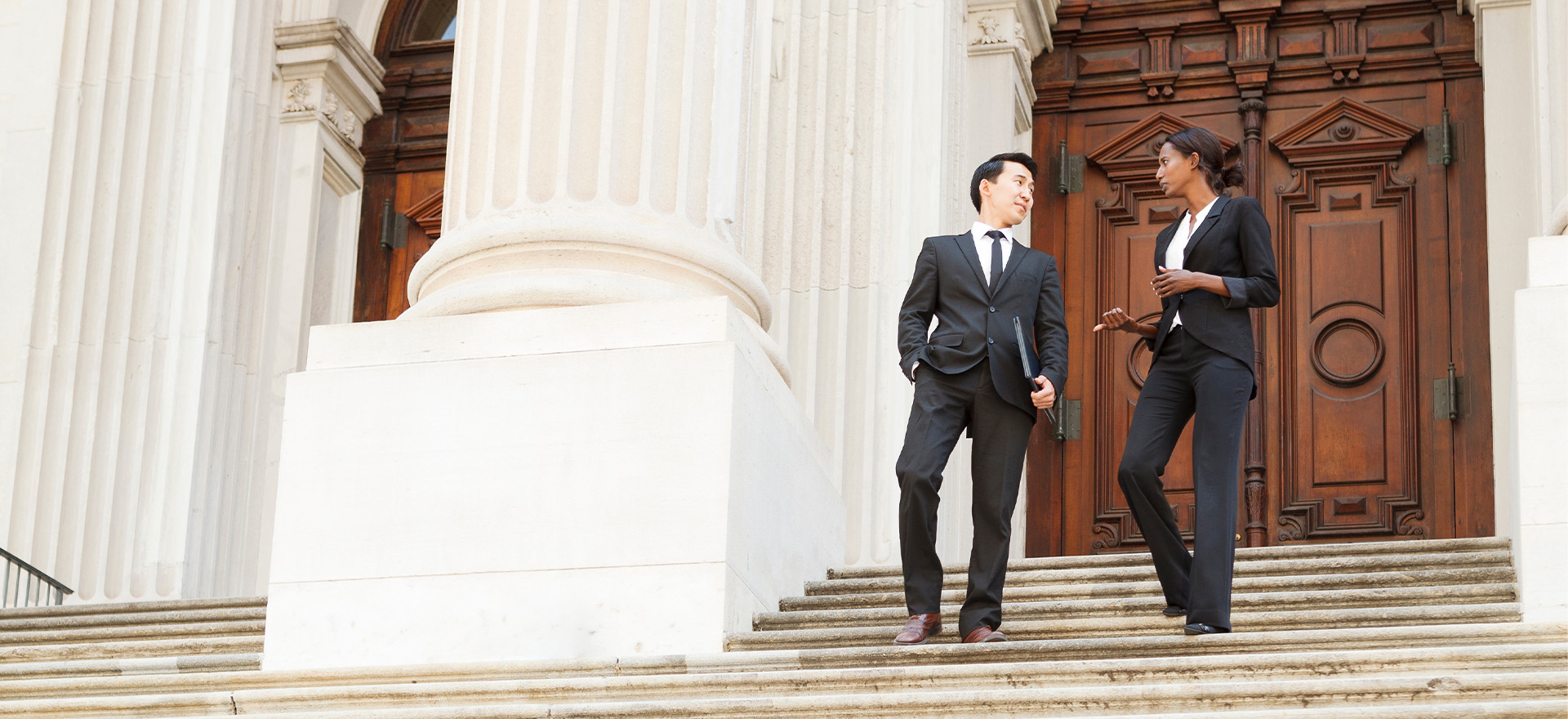 people in suits walking down stairs of government building