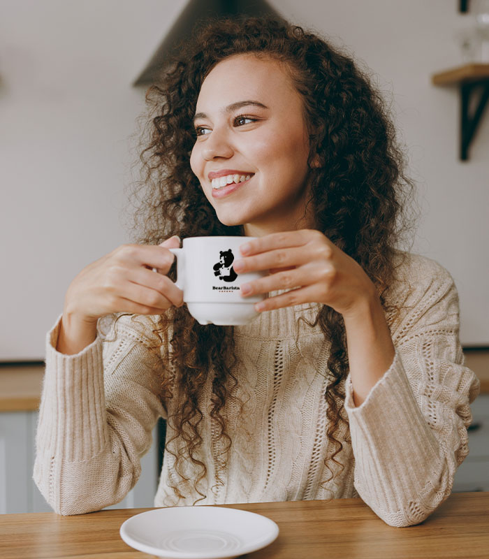 woman drinking from a white mug