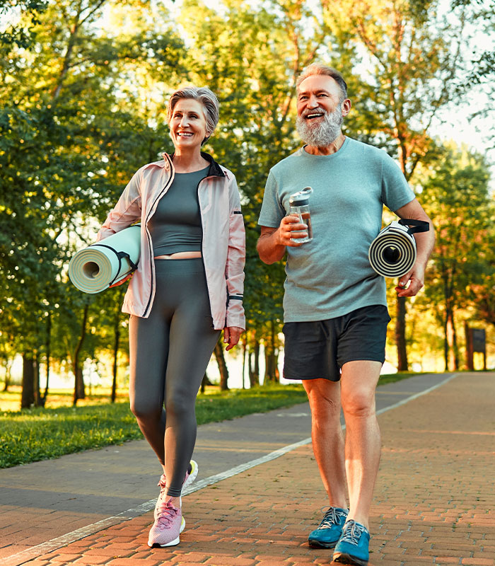 two people walking with yoga mats