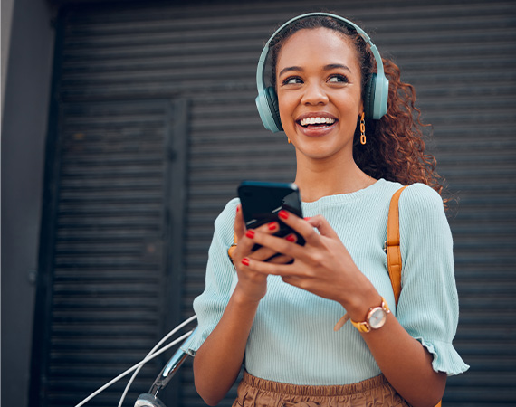 woman wearing headphones and holding a phone